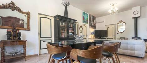 A dining area with a round table, wooden chairs, and a patterned rug.