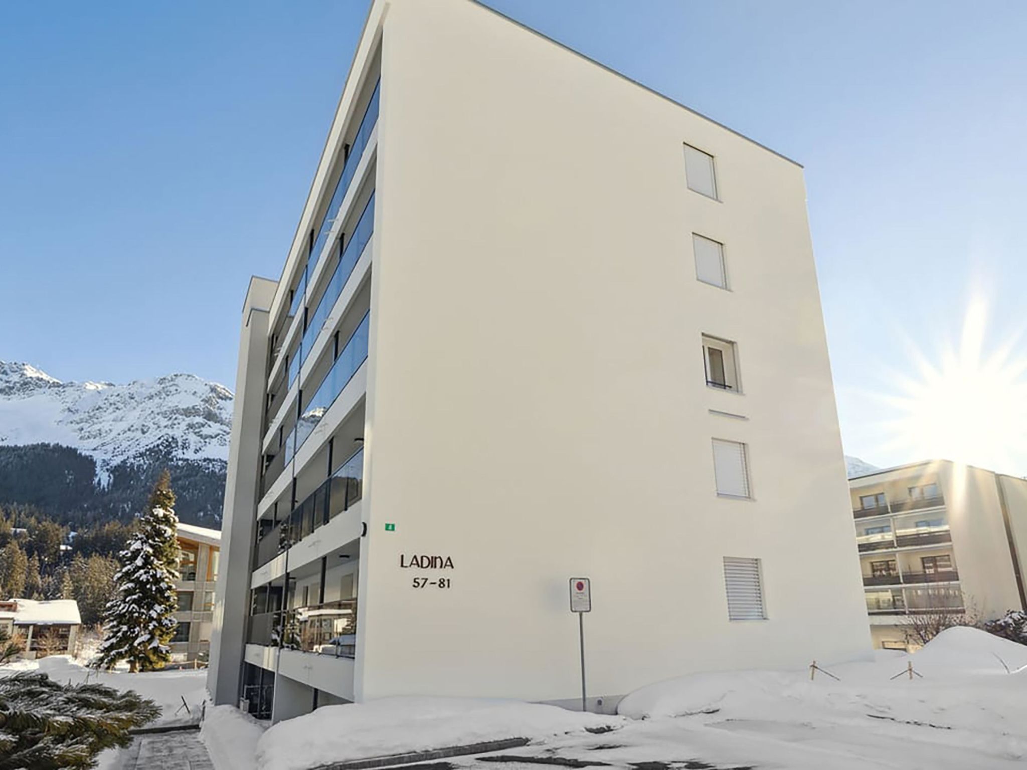 Ein modernes Mehrstöckgebäude mit flacher Fassade und einer Reihe von Fenstern, mit der Aufschrift 'LADINA 57-81'.