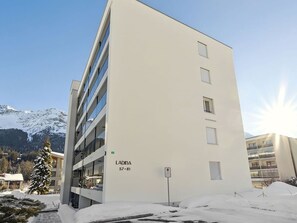 Ein modernes Mehrstöckgebäude mit flacher Fassade und einer Reihe von Fenstern, mit der Aufschrift 'LADINA 57-81'.