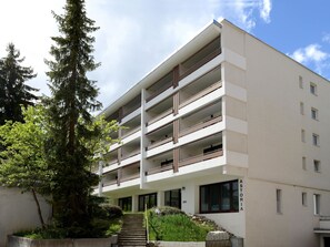 Ein mehrstöckiges Gebäude mit Balkonen und einer Treppe, die zum Eingang führt, mit einem Schild, auf dem 'ASTORIA' steht.