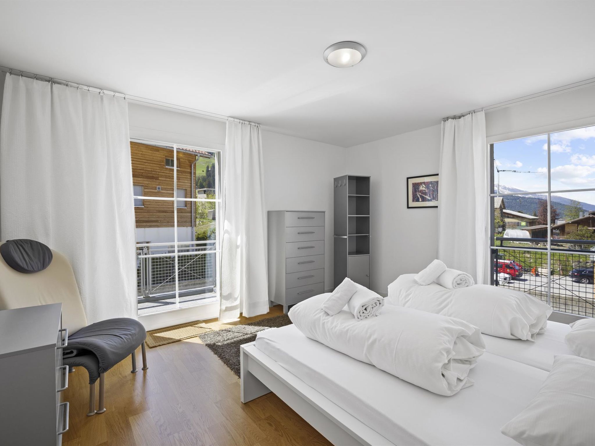 Une chambre moderne avec un grand lit, un bureau et une vue sur l’extérieur.