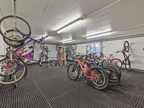 A bike storage area with multiple bicycles, a ceiling-mounted bike rack, and a door leading to another room. - Nr.06 Haus Sursilvana Appartement/Fewo,   Nr.06 Haus Sursilvana IH by Interhome (Lenzerheide)