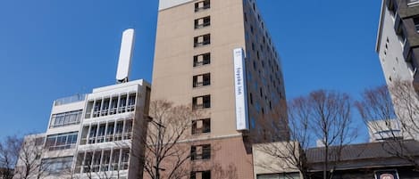 A multi-story building with a prominent sign for 'toyoko-inn.com' on the top.