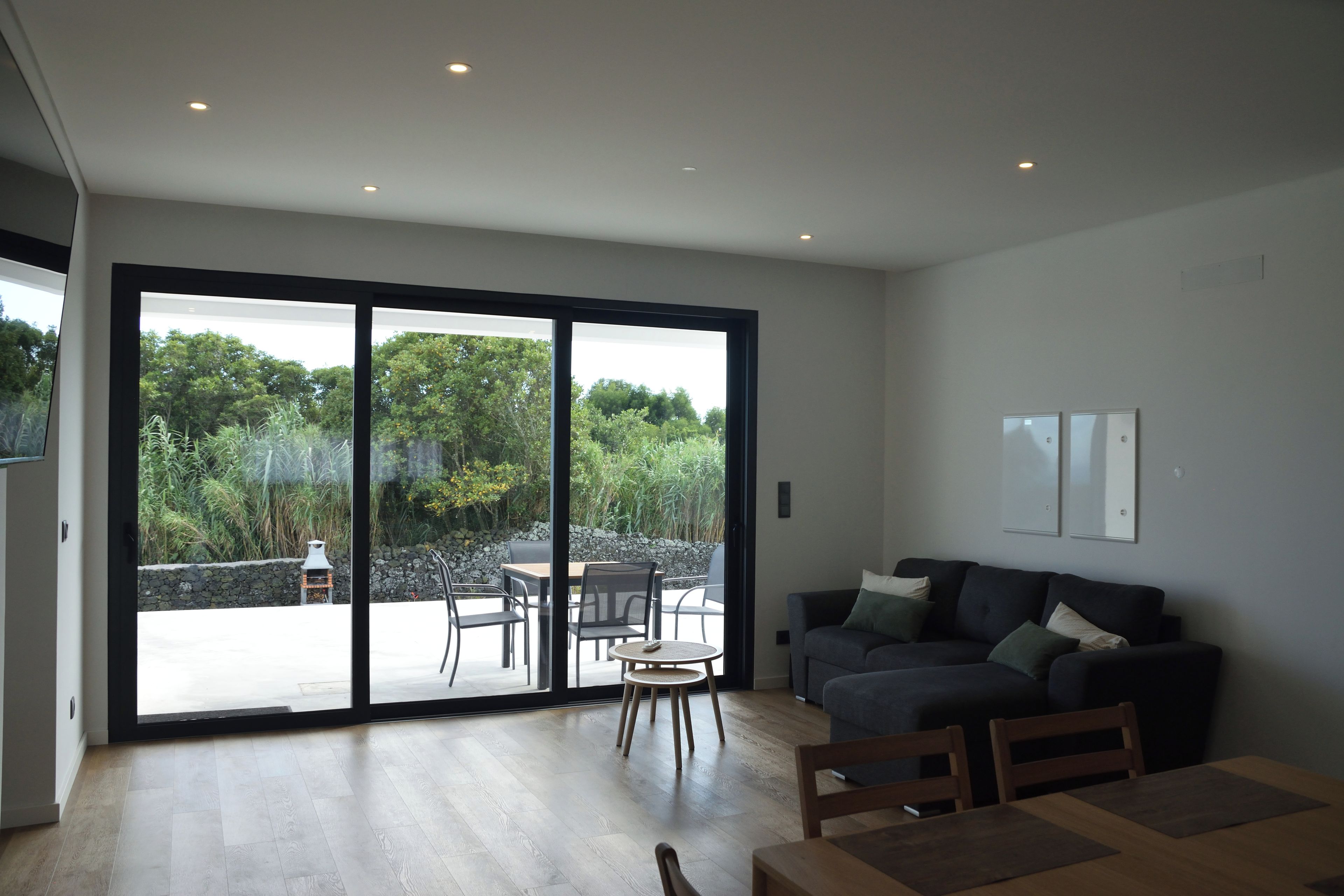 A modern living room with a sliding glass door leading to an outdoor patio area.