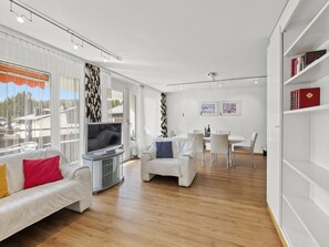 A modern living room with a sofa, TV, and dining area. - Nr.55 Haus Sotmirana Appartement/Fewo,   Nr.55 Haus Sotmirana by Interhome (Lenzerheide)