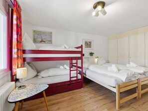 A bunk bed room with a red ladder, a small table with a lamp, and a radiator. - Nr.55 Haus Sotmirana Appartement/Fewo,   Nr.55 Haus Sotmirana by Interhome (Lenzerheide)
