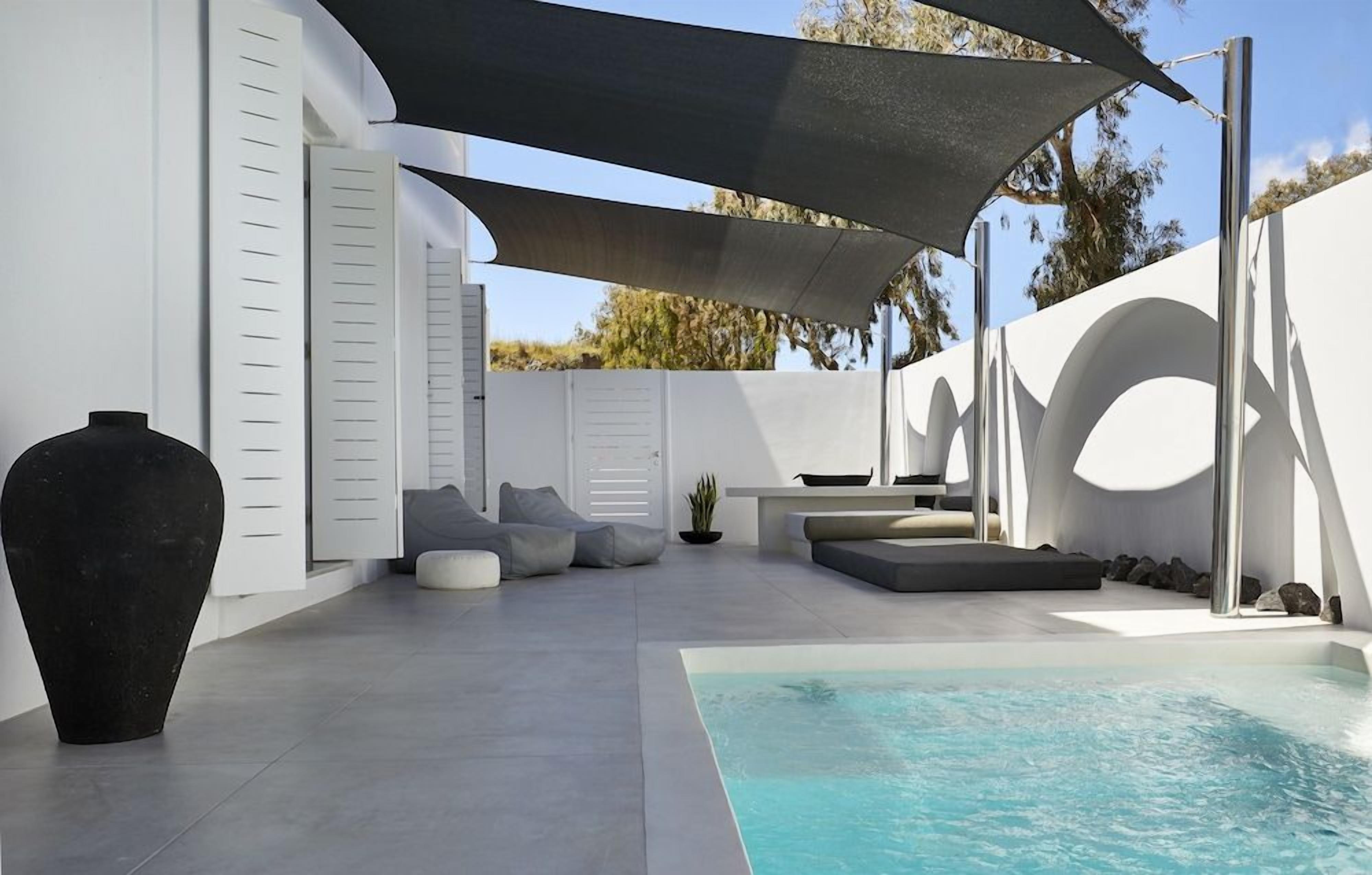 Un área de piscina moderna al aire libre con una zona de estar integrada, un gran jarro negro y una pérgola con sombra.