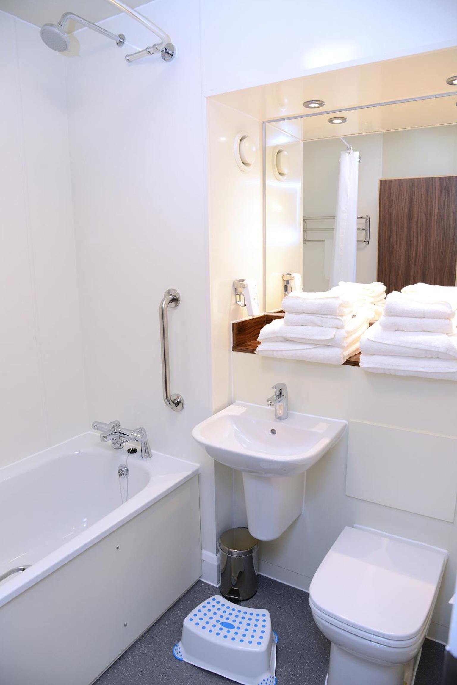 A modern bathroom with a bathtub, sink, and toilet.
