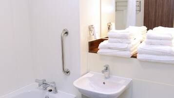A modern bathroom with a bathtub, sink, and toilet.