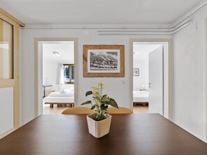 A room with a wooden table, a framed picture on the wall, and a potted plant. - Bellavista 4 Appartement/Fewo, Bad, WC, 2 Schlafräume by Interhome (Parpan)