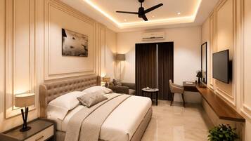Une chambre d’hôtel équipée d’un lit, d’une table de chevet, d’une lampe, d’un bureau, d’une chaise, d’une télévision et d’un ventilateur de plafond.