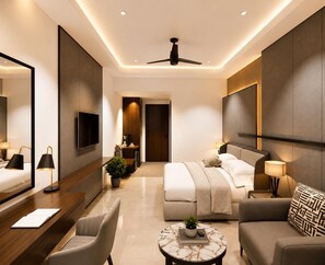 A modern hotel room with a bed, a seating area with a table, a TV, and a ceiling fan. - Fun Hotels Vadodara (Vadodara)