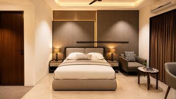 Un dormitorio moderno con una cama grande, mesitas de noche, un sofá y un ventilador de techo.