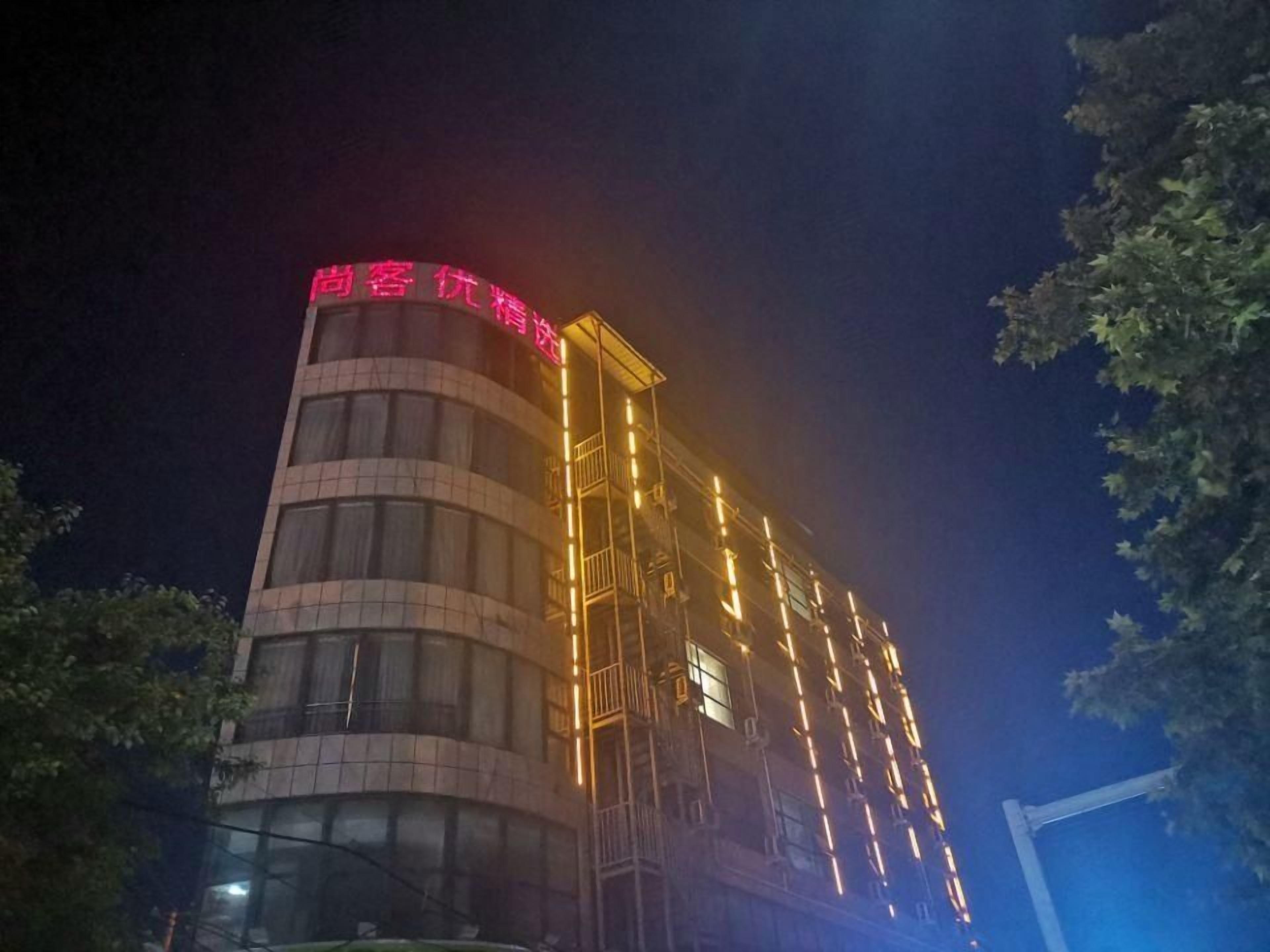 A multi-story building with a prominent red sign at the top.