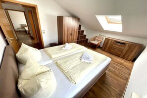 Ein Schlafzimmer mit zwei Betten, einem Holzschrank und einem Oberlicht.