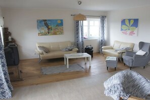 A living room with a sofa, armchairs, a coffee table, and a patterned rug. - Holiday apartment in Rees with swimming pool (Rees)