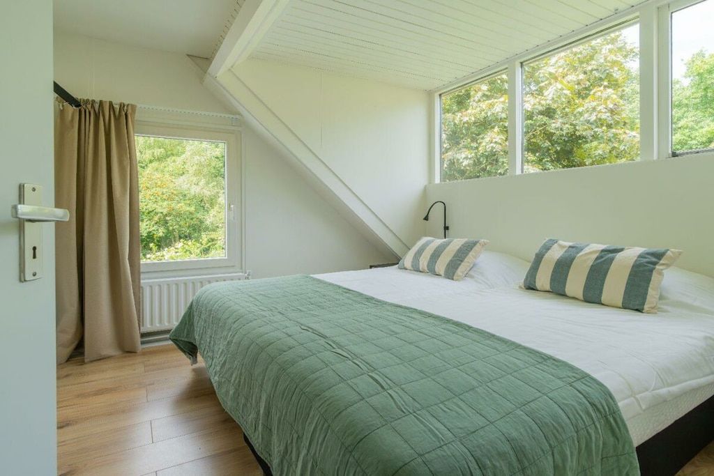 Une chambre à coucher avec un lit, une fenêtre et une porte.