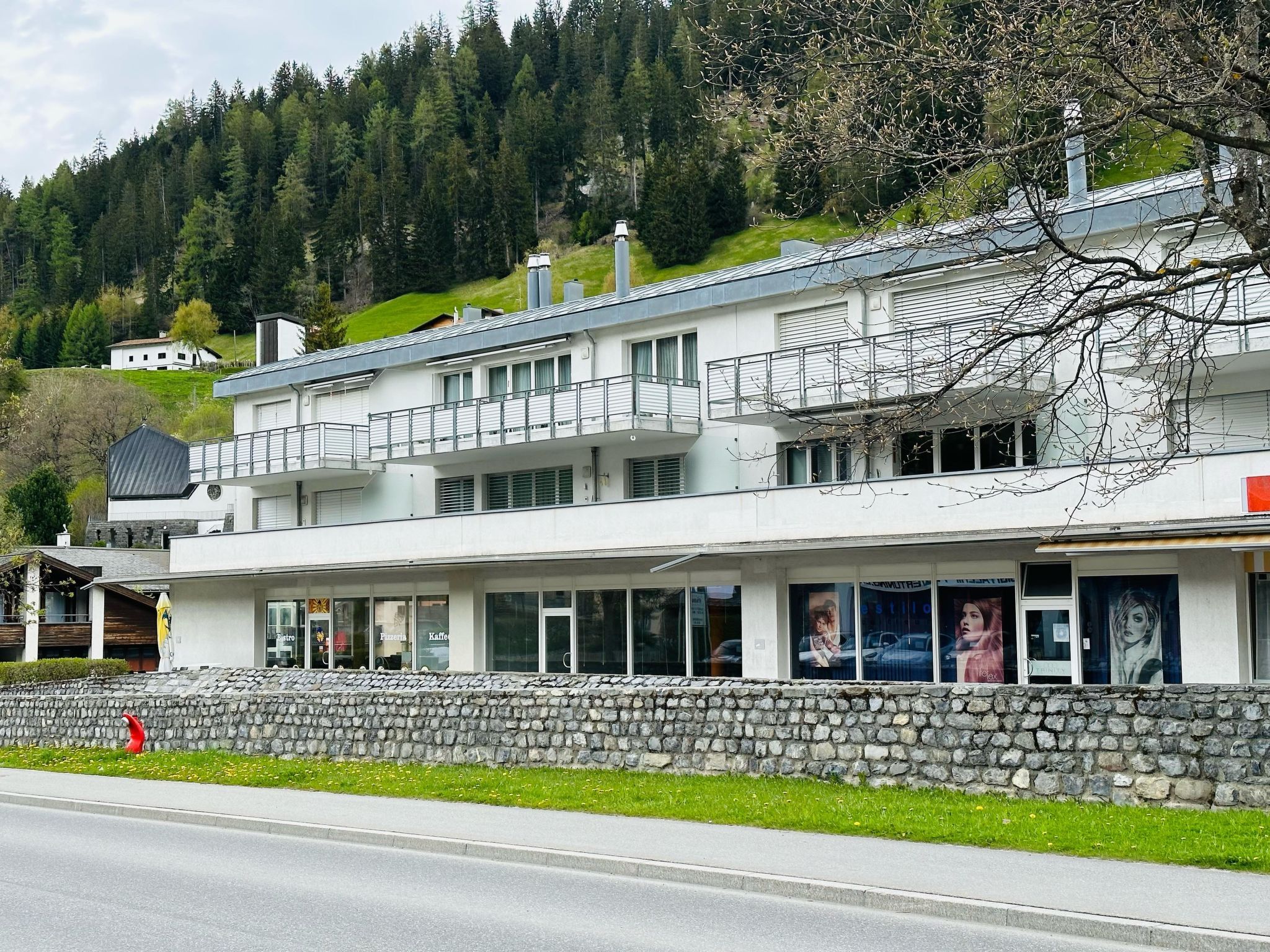 A multi-story hotel with a stone facade, balconies, and a restaurant with visible signage.