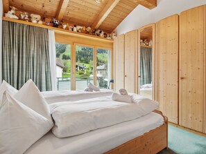 A bedroom with a bed, wooden wardrobe, and a view of the outdoors. - Casa Hermi Appartement/Fewo 2.5 Zimmerwohnung IH by Interhome (Churwalden)