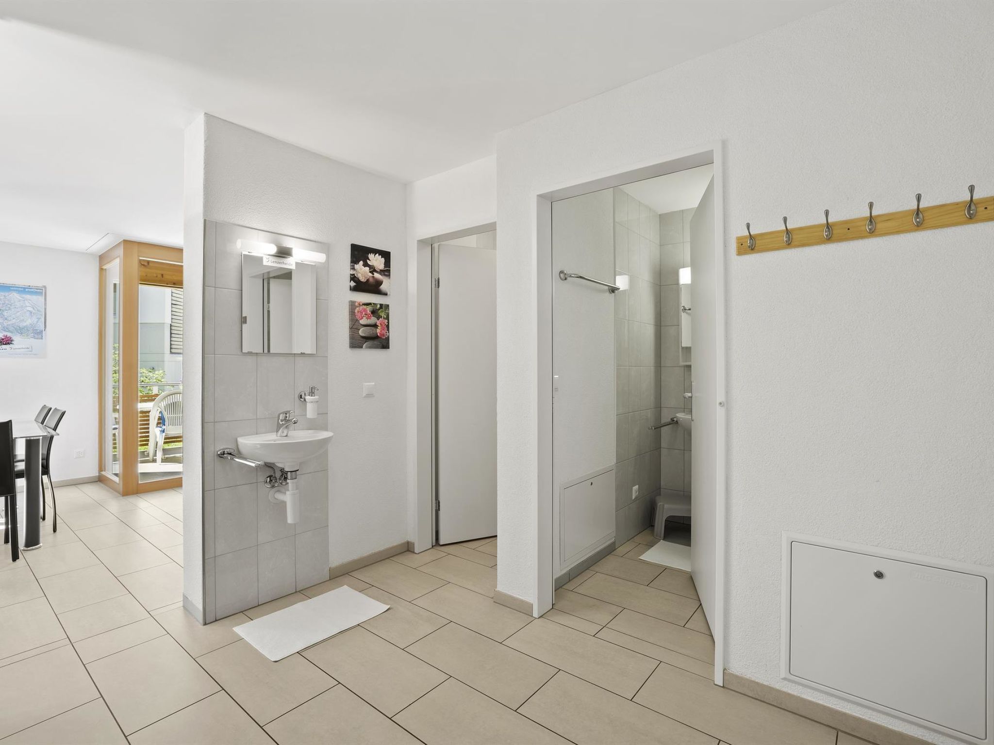 Un baño moderno con lavamanos, espejo y ducha.
