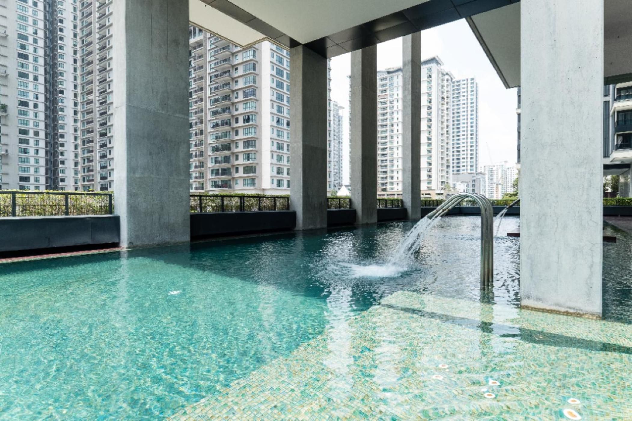 An indoor swimming pool with clear water, surrounded by high-rise buildings.