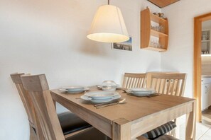 Ein Esstisch mit Tellern, Besteck und einer Lampe.