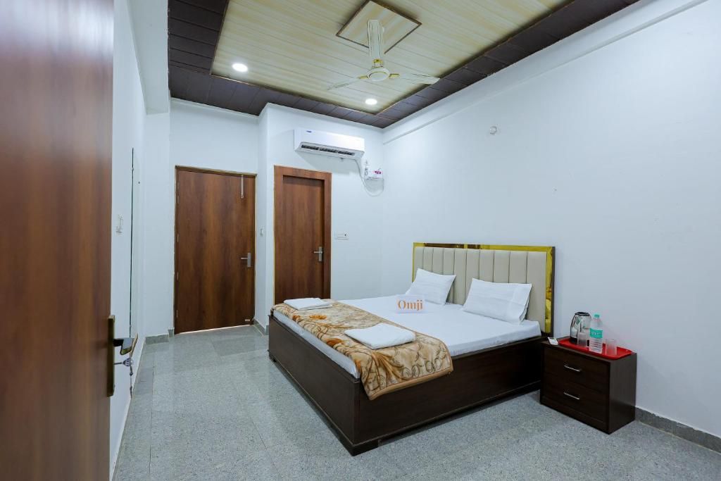 A hotel room with a bed, bedside table, wardrobe, and an air conditioning unit.