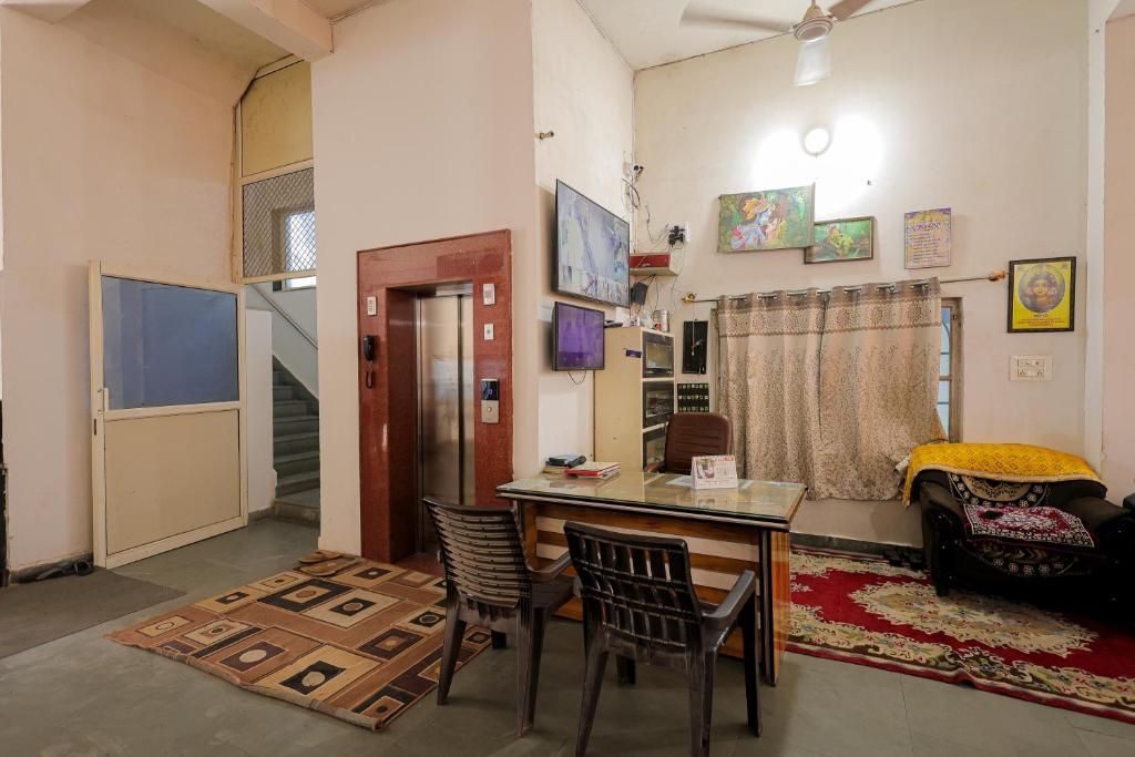 A living room with a sofa, a dining table with chairs, a television, and a staircase.