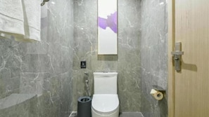 A bathroom with a toilet, a trash bin, and a towel hanging on the wall. - Lavande Hotel (Kunming)