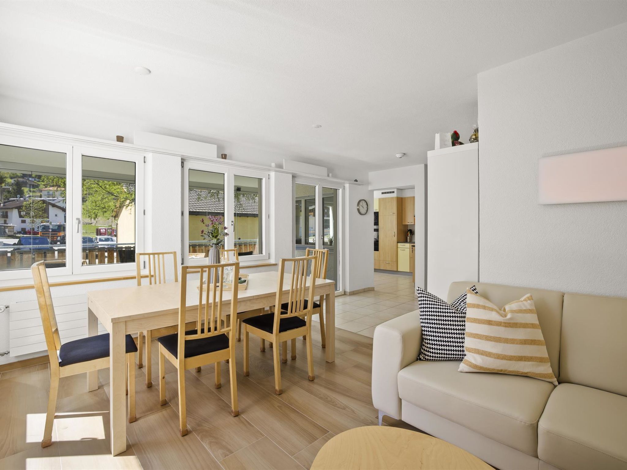 Un soggiorno moderno con un divano beige, un tavolo da pranzo in legno e sedie.