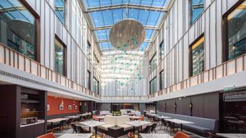 A spacious indoor dining area with high ceilings and a central chandelier.