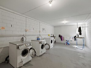 A laundry room with three washing machines, a drying rack, and a clothesline. - Nr.43 Haus Sotmirana Appartement/Fewo Nr.43 Haus Sotmirana IH by Interhome (Lenzerheide)