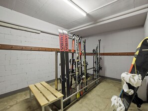 A ski storage area with a bench and a rack holding skis and ski poles. - Nr.43 Haus Sotmirana Appartement/Fewo Nr.43 Haus Sotmirana IH by Interhome (Lenzerheide)
