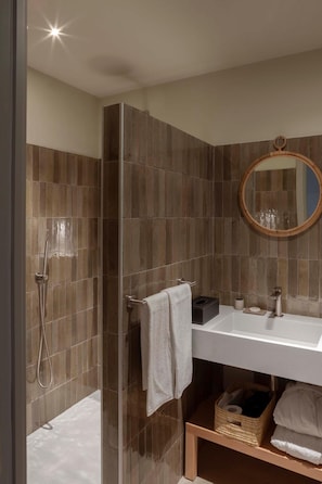 A modern bathroom with a glass-enclosed shower, a white sink, and a mirror with a wooden frame. - Le Ginestre Residence - Is Molas Resort (Pula)