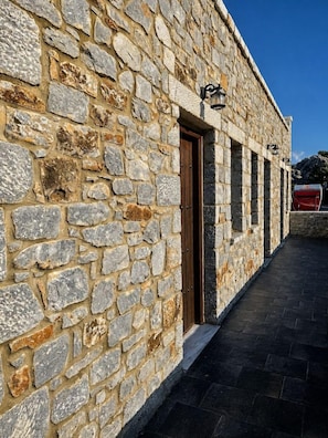 Um edifício de pedra com uma porta de madeira e um caminho estreito que o leva até ele.