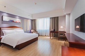 A hotel room with a large bed, a desk, a chair, a TV, and a painting on the wall. - Borrman Hotel Canton Tower Sun Yat Sen University Metro Station Pazhou Exhibition Center (Guangzhou)
