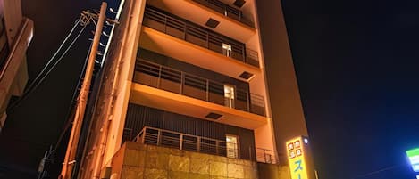 A multi-story building with a prominent entrance and a sign indicating a business or commercial area.