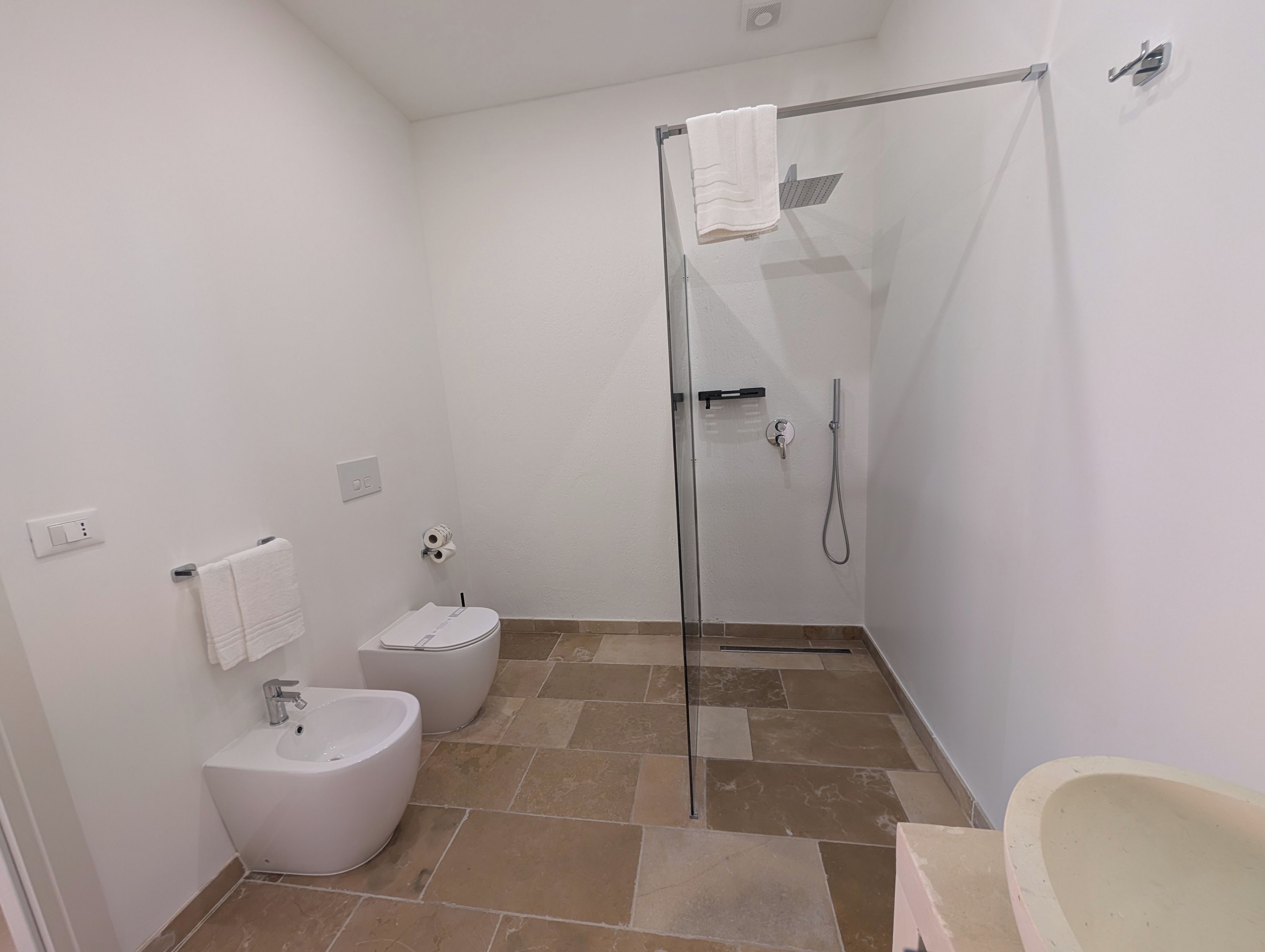 Ein modernes Badezimmer mit einer Duschkabine, einer Toilette und einem Bidet.