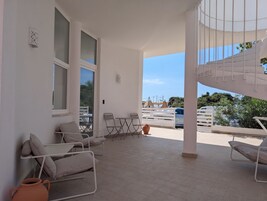 Un espacio al aire libre cubierto con un conjunto de asientos, que incluye una mesa y sillas, y una escalera en espiral.
