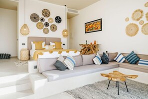 A modern bedroom with a bed, a sofa, a coffee table, and decorative wall art. - Tulum Beach Resort & Spa Dakhla (Dakhla)