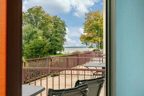 A balcony with a view of a body of water, surrounded by trees and a metal railing. - Studio 'AhoiPause Steinhude' with Lake View, Terrace and Beach Chair (Wunstorf)