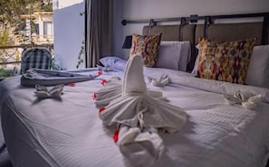 A hotel room with a neatly made bed, a suitcase, and a chair.