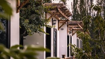 Un edificio con fachada blanca, vigas de madera y ventanas de marco negro.