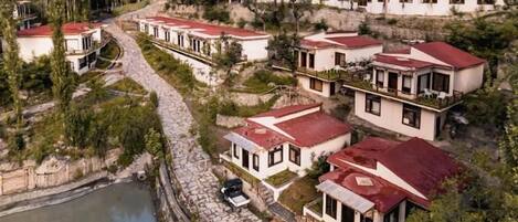 A residential area with multiple houses, a paved road, and a body of water.