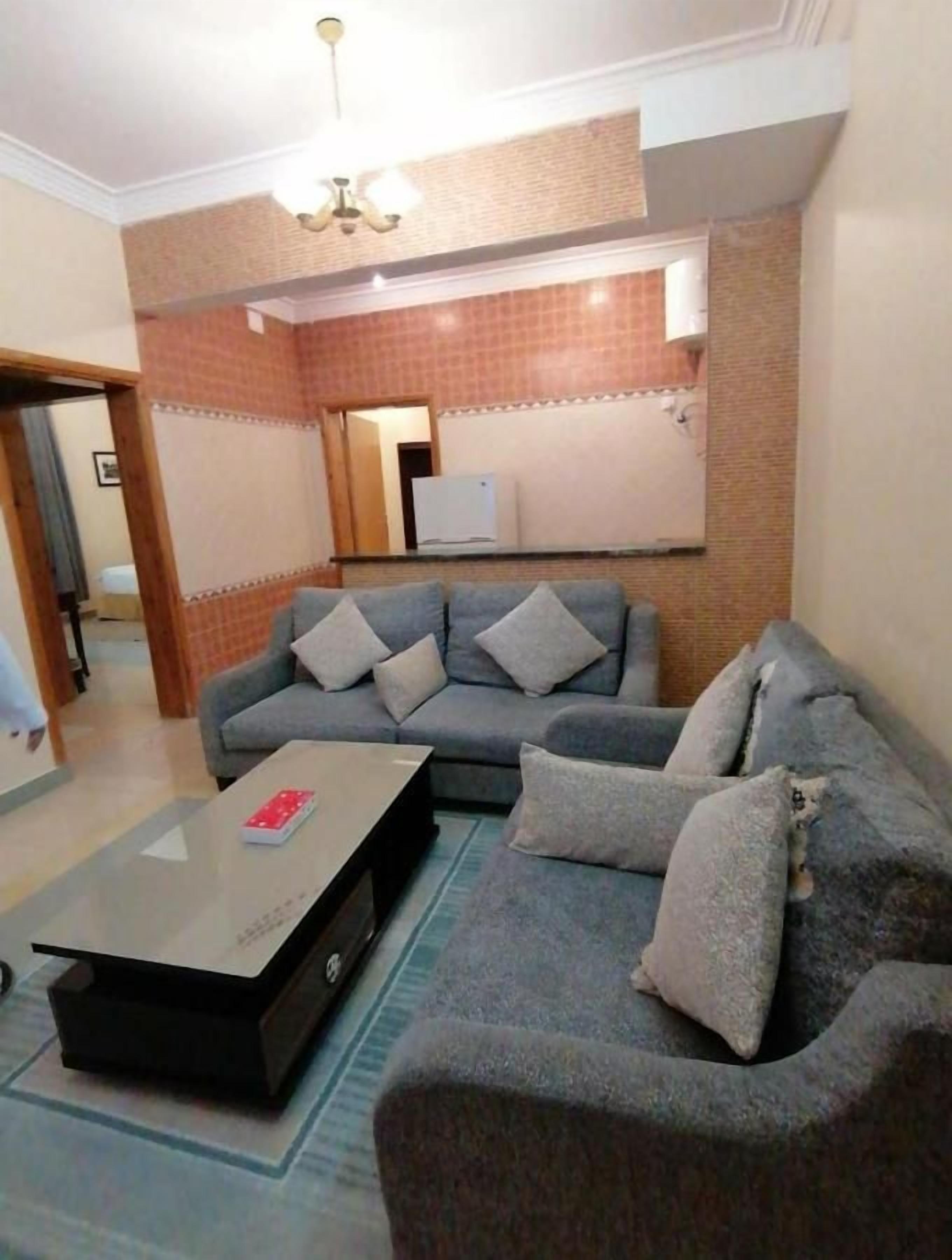 A living room with a sofa set, a coffee table, and a television.