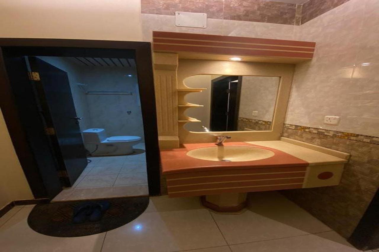 Une salle de bain avec un lavabo, un miroir et des toilettes.