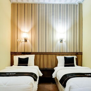 A hotel room with two beds, wooden headboard, wall-mounted lights, and a decorative border. - OYO 2255 Hotel Aifih (Palembang)