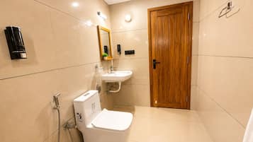 Un baño con inodoro, lavamanos y ducha.