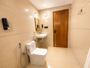 A bathroom with a toilet, sink, and shower.