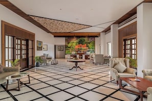 A spacious lobby with a checkered floor, a central round table, and seating arrangements. - Bookmark Resort Jogi Mahal Ranthambore (Sawai Madhopur)